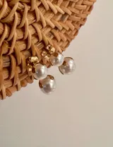 Pack de caravanas doradas con perlas en dos tamaños, chicas y medianas, destacando un diseño elegante y atemporal.