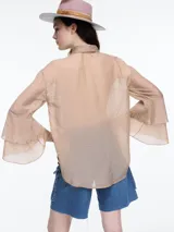 Camisa negra de lyocell y poliamida, con cuello clásico, mangas largas acampanadas con volados y cierre frontal con botones.