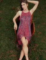 Vestido largo de crochet color fucsia con lurex y flecos en el ruedo.