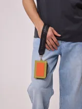 Billetera tarjetero negra de poliuretano con cierre y correa para colgar al cuello con logo Rusty estampado.