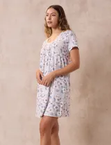 Camisón corto negro con lunares blancos, de tejido suave y escote redondo con detalle plisado y moño blanco.