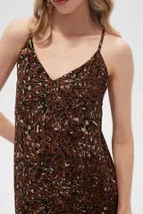 Vestido largo con estampado animal print en tonos beige y negro, breteles finos y corte holgado.