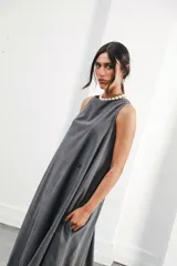 Vestido largo gris sin mangas, con escote redondo, bolsillos laterales y logo bordado en el frente.