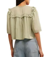 Blusa blanca de algodón con escote en V, mangas cortas y detalle de bordado tipo encaje.