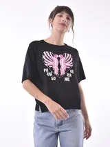 Remera negra de corte holgado con estampado de dos aves rosadas formando un corazón y texto en blanco.