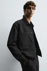Sobrecamisa negra relaxed fit confeccionada en tejido con algodón, lino y lyocell. Cuello solapa y manga larga acabada en puño con botón. Bolsillos plastrón con solapa en pecho y laterales en cadera. Cierre frontal de botonadura.