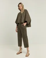 Pantalón recto negro con estampado geométrico dorado, confeccionado en algodón con bordado de poliéster.