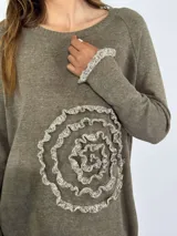 Sweater azul con diseño de flor en el frente y detalles de volados en puños y ruedo.