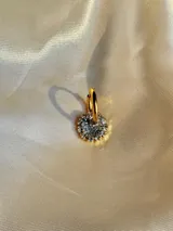 Arito dorado con forma circular, centro negro y strass blancos alrededor. Se vende por unidad.