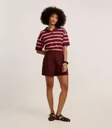 Blusa de punto con cuello polo y rayas horizontales en tonos borgoña y rosa.