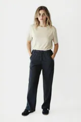 Pantalón negro de corte recto y tiro alto, con cintura elástica y cordón ajustable.