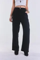 Pantalón negro de lino, de corte amplio, con pretina de botón y cierre. No tiene lycra.