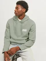 Canguro verde claro con capucha y cordones ajustables. Tiene un bolsillo tipo canguro en la parte delantera y el logo de Jack & Jones estampado en blanco en el pecho.