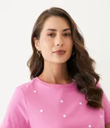 Remera rosa de algodón con cuello redondo y lunares blancos.