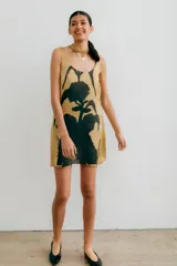 Vestido corto color beige con estampado floral abstracto en negro, de corte recto y sin mangas.