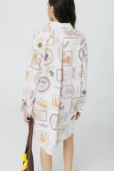 Camisa blanca de manga larga con estampado de frutas y verduras.