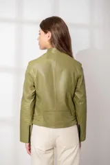 Chaqueta de cuero color verde oliva, estilo motoquera, con cierre frontal cruzado grueso en negro, cuello solapa y detalles acolchados en hombros y codos.