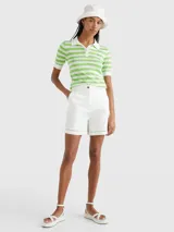 Chomba de punto a rayas horizontales verdes y blancas, con cuello polo blanco, cartera de cuatro botones y logo bordado de Tommy Hilfiger en el pecho.