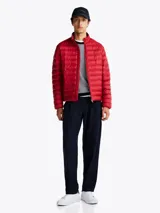 Campera acolchada roja de Tommy Hilfiger, con cuello alto y cierre de cremallera. Cuenta con dos bolsillos laterales con cremallera y logo bordado en el pecho.