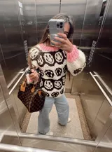 Sweater tejido a mano en lana merino virgen sin teñir, con diseño de caritas en lana chocolate, puños y cuello color rosa.