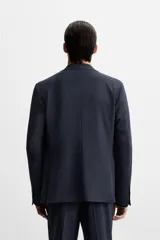 Blazer slim fit azul marino confeccionada en tejido con 17% de lana. Cuello con solapas de muesca, manga larga acabada en puño con detalle de botones, bolsillo de vivo en pecho y de solapa en cadera, detalle bolsillo interior, bajo con aberturas en espalda y cierre frontal con botones.