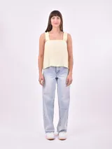 Blusa sin mangas color amarillo pálido, con breteles anchos con volados y escote cuadrado.
