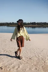 Remera oversize a rayas horizontales color verde claro y blanco, de mangas largas y cuello redondo.