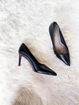 Zapato de tacón alto Iara, color negro charol, con punta fina y suela roja. Fabricado en cuero.