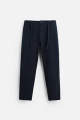 Pantalón azul marino de corte recto, confeccionado en tejido de algodón y lino. Tiene cintura elástica ajustable con cordón, bolsillos delanteros y traseros de vivo. Cierre frontal con cremallera y botón.