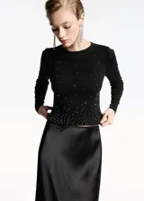 Jersey negro de punto fino con strass, cuello redondo y manga larga.