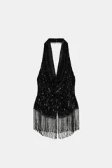 Top negro de lentejuelas con cuello halter, escote fluido, espalda descubierta y flecos en el bajo.