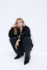 Campera negra con capucha y cierre frontal, con bolsillo tipo canguro y estampado blanco con la inscripción 'Seine Paris'.