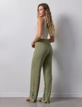 Pantalón verde oliva de rayón con cintura elastizada tipo smock y bordados florales en los bajos.