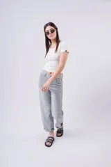 Jean de mezclilla celeste claro, corte wide leg y tiro alto, con pequeños apliques brillantes distribuidos por toda la prenda. El bajo está doblado.