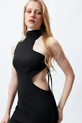 Vestido corto negro ajustado al cuerpo, con cuello halter y aberturas cut out en el pecho y la cintura. Presenta lazos laterales ajustables.