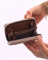 Billetera de cuero color gris topo con cierre perimetral y logo de la marca grabado en el frente.