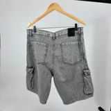 Bermuda de jean color gris claro, con diseño de bolsillos cargo y corte cómodo.