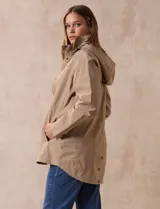 Campera impermeable color gris claro, marca Gallery. Tiene abertura central con cierre oculto y botones a presión, bolsillos delanteros y capucha plegable en el cuello.