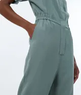 Mono largo color verde con cuello camisero, manga corta, abertura frontal con botones, cintura elástica y pernera ancha.