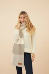 Chal unisex de lana fina sin teñir, realizado con retazos de telas diseñadas por Don Baez. Presenta una grifa de cuero aplicada.