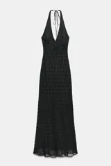 Vestido largo negro con lunares, cuello halter y escote pico.