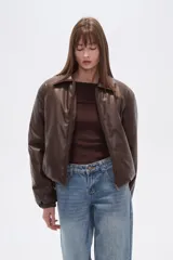 Campera estilo bomber de eco-cuero color marrón oscuro, con cuello camisero, cierre frontal y puños y cintura ajustados.