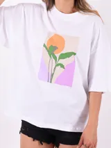 Remera blanca de corte holgado con estampa rectangular con una planta y un sol.