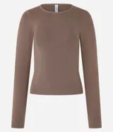 Blusa color beige de jacquard con cuello redondo y mangas largas.
