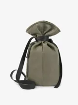 Bolso tipo macuto mediano color verde, confeccionado en poliéster. Tiene un compartimento principal con cierre de cremallera lateral y un bolsillo interior con cremallera. Cuenta con asa larga regulable y cinta a contraste a modo de estrangulador.