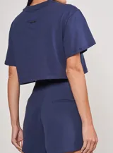 Remera corta azul con cuello redondo y logo Colcci bordado en el frente.