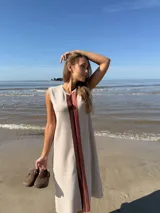 Vestido midi sin mangas color beige, con corte recto y detalle de franja vertical marrón en el centro.