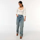 Pantalón de jean celeste, de corte recto y tiro alto, con lavado gastado y dobladillo ancho.