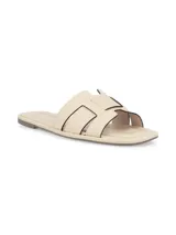 Sandalia plana en cuero negro, con diseño simple y moderno, ideal para el uso diario.