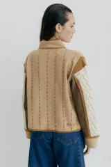 Chaqueta tejida en lana merino y lambswool color negro, con detalles bordados en beige y marrón.